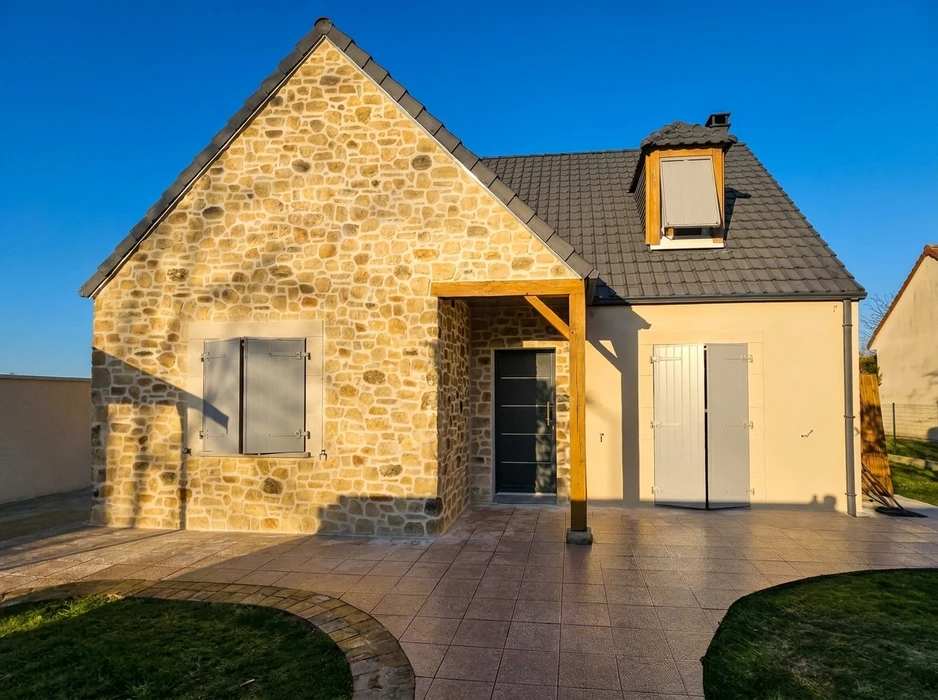 Maison individuelle neuve, vue extérieure, façade en pierre de pays appareillée, enduit beige sur partie droite