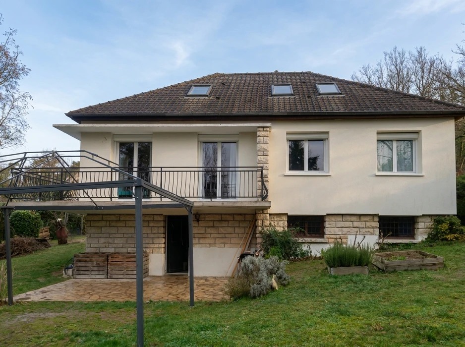 Maison individuelle vue de jardin, style années 70, enduit blanc, soubassement en pierre de taille calcaire