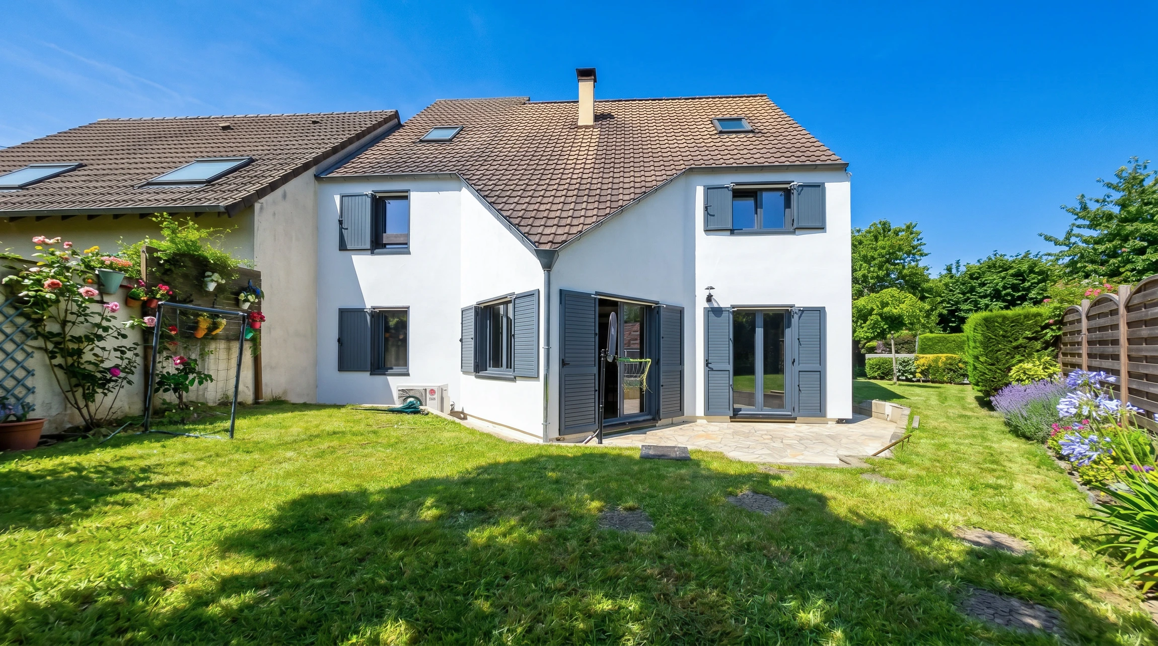 Deux peintres en bâtiment travaillent sur échafaudage tubulaire contre façade de maison